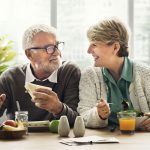 Dental implant patients smiling during a meal