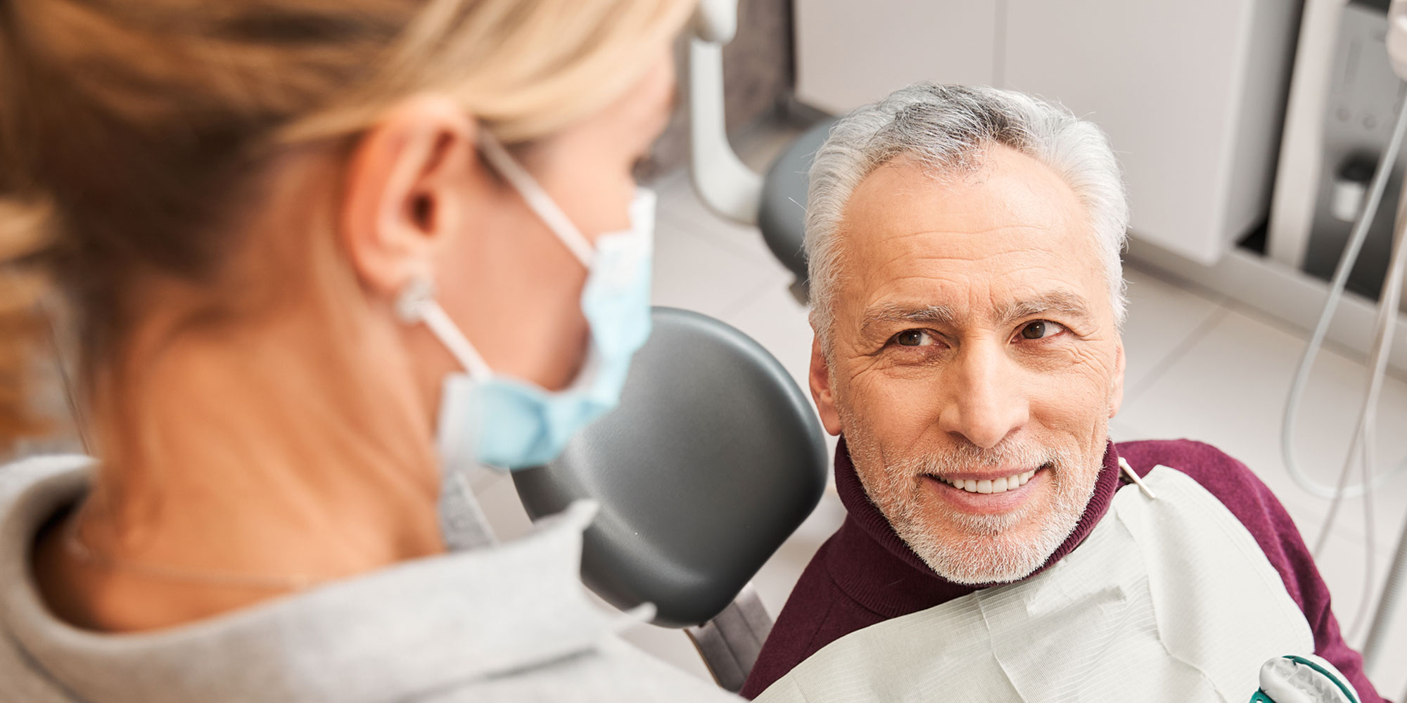 older dental implant patient with surgeon