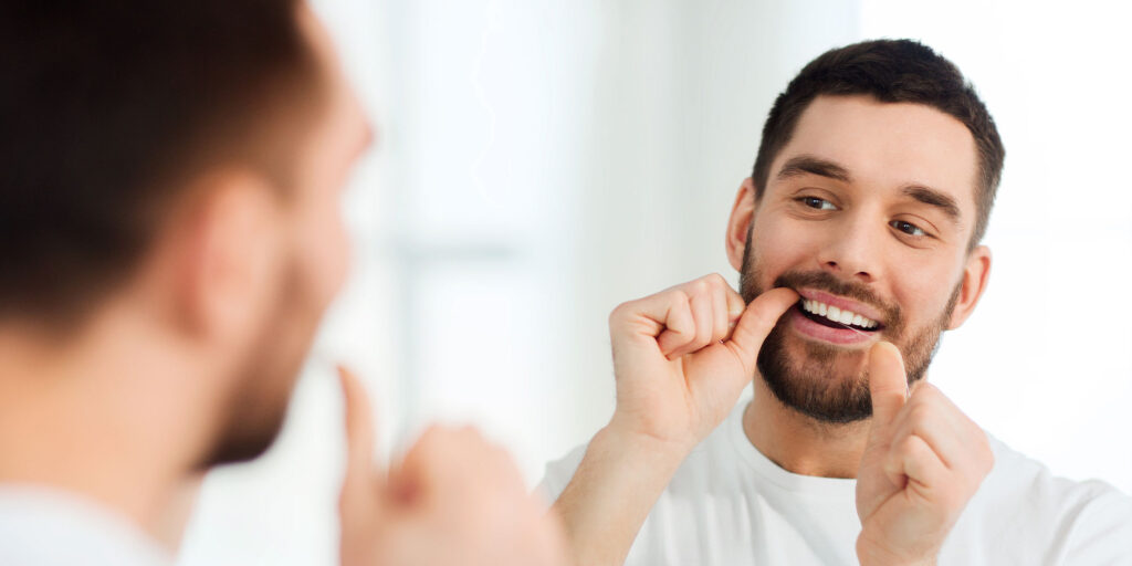 guy flossing his teeth